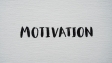 Inspirational word 'Motivation' in black on a white textured canvas background.