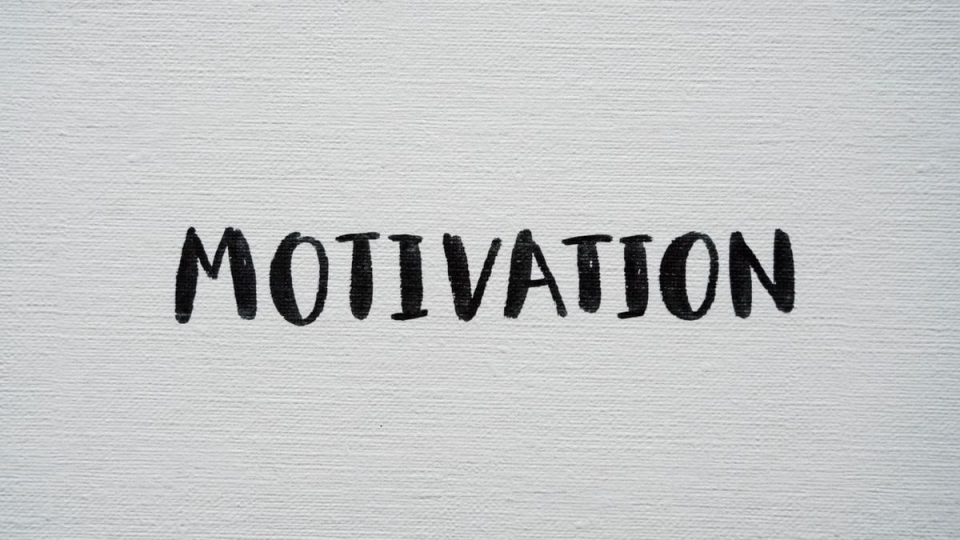 Inspirational word 'Motivation' in black on a white textured canvas background.